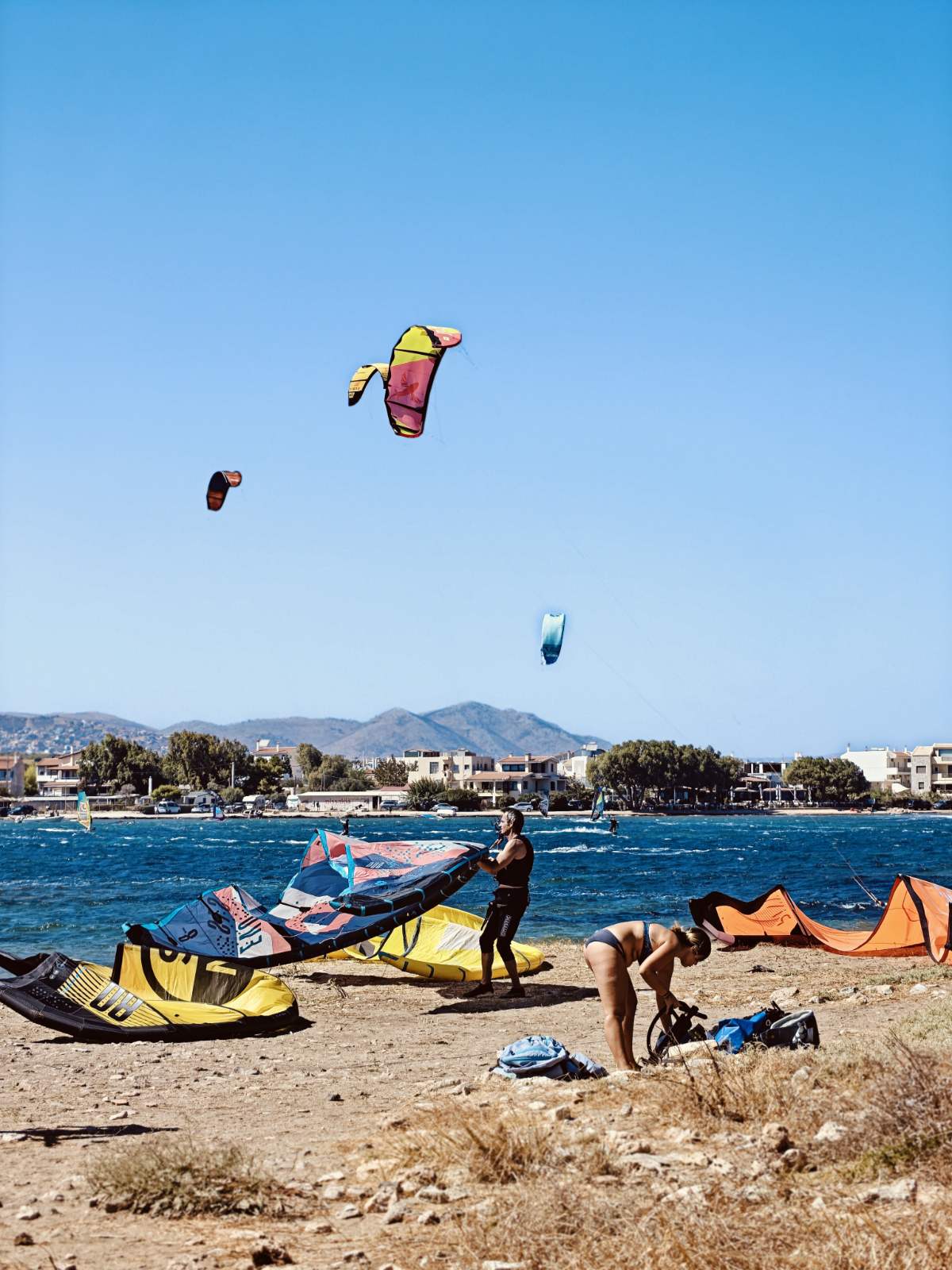 Kitesurfers preparing equipment on Nissakia beach in Loutsa, near Athens